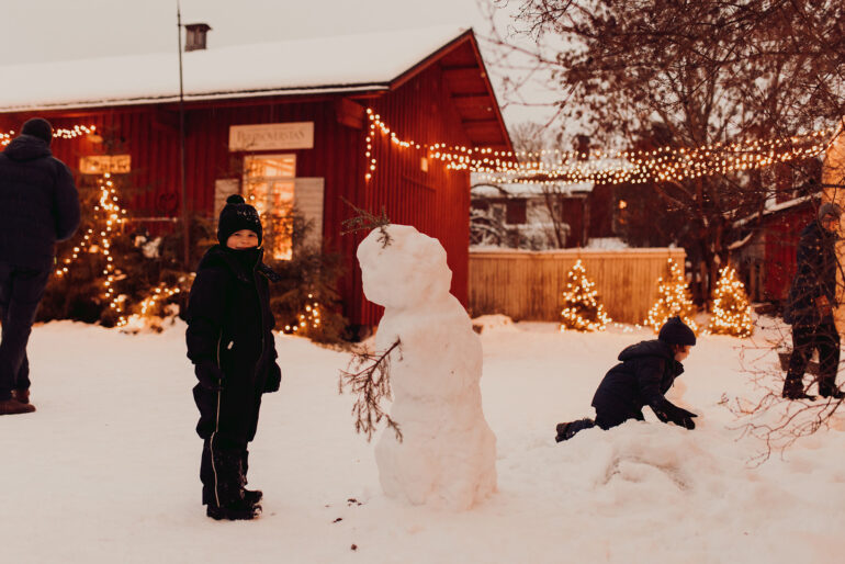Lapset rakentamassa lumiukkoa Tammelan tonttumaassa.